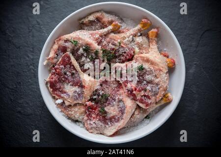 Gambe di mallard selvatiche crude che sono state lasciate marinare in sale ed erbe prima di essere cucinate. Questa è una versione fatta in casa del famoso confit d'anatra. Dor Foto Stock