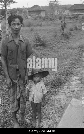 Foto Reportage Palembangs uomo indonesiano (contadino o contadino) con un piccolo bambino, indossando un cappello grande Data: Gennaio 1947 posizione: Indonesia, India orientale olandese, Palembangs, Sumatra Foto Stock