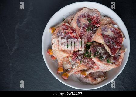 Gambe di mallard selvatiche crude che sono state lasciate marinare in sale ed erbe prima di essere cucinate. Questa è una versione fatta in casa del famoso confit d'anatra. Dor Foto Stock