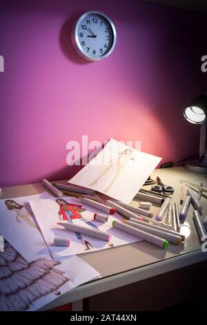 scrivania con schizzi di moda e pastelli colorati Foto Stock