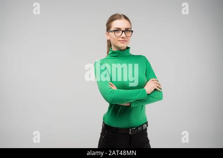 Giovane ragazza in abiti modesti si leva le braccia incrociate Foto Stock