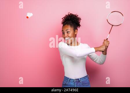 Bella ragazza mulatto giocare badminton in studio con emozione felicità Foto Stock