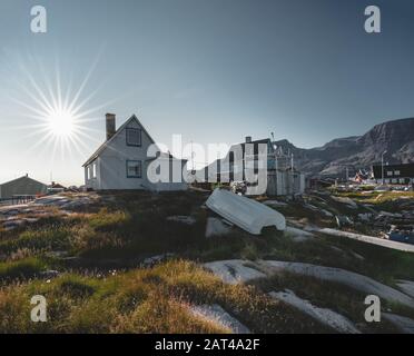 Vista di colorate case della Groenlandia di Disko Isola, arctic città di Qeqertarsuaq. Situato nella baia di Disko. Cielo blu e giornata di sole. Tabella montagne Foto Stock