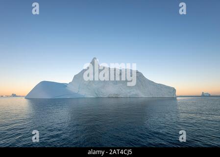 Iceberg al tramonto a Hall Brewing, parte del sistema di fiordo Scoresby Sound, Groenlandia orientale Foto Stock