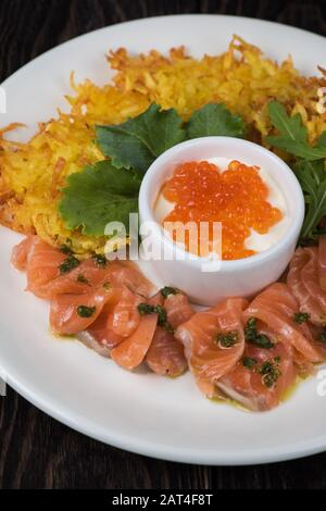 frittelle di patate, pesce di salmone e caviale rosso Foto Stock