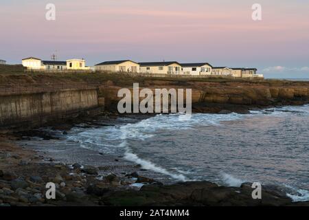 Parco di roulotte di Newbiggin-by-the-Sea al crepuscolo, Northumberland Foto Stock