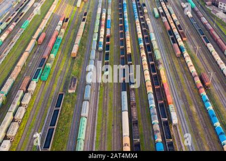 Vista aerea in prospettiva di binari ferroviari, stazione di smistamento merci. Molte auto ferroviarie diverse con merci e materie prime Foto Stock