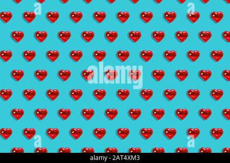 San Valentino sfondo. Motivo di cuori rossi di vetro su sfondo blu. Minimalismo della carta, simbolo dell'amore Foto Stock