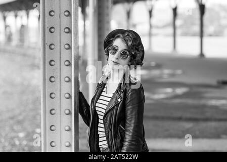 Ritratto di una donna di venti anni che indossa una giacca in pelle nera e occhiali da sole Foto Stock