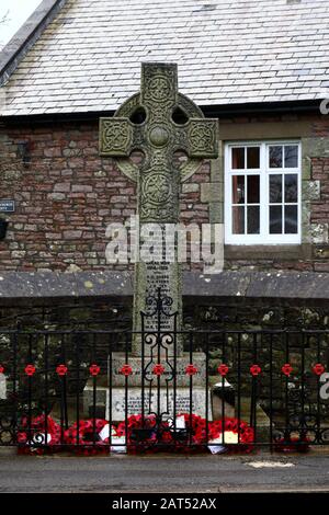 Poppy wreaths alla base del memoriale di guerra nel villaggio di Coity, Mid Glamorgan, Galles, Regno Unito Foto Stock