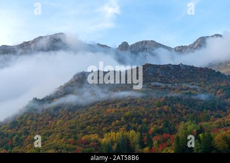 Nebbia che rivela la catena montuosa delle Alpi liguri, regione Piemonte, provincia di Cuneo, Italia nord-occidentale Foto Stock