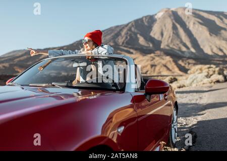 Ritratto di stile di vita di una giovane donna che si gode viaggio su strada nella valle del deserto, uscire dalla auto convertibile sulla strada Foto Stock