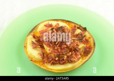 Spuntino sano di formaggio fuso, fette di mela e tacchino pancetta bit sulla tortilla su piatto verde con tovaglia bianca di fondo Foto Stock