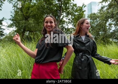 Giovani donne del Medio Oriente e del caucaso ballano e ridono nel parco urbano. Scatto medio. Foto Stock