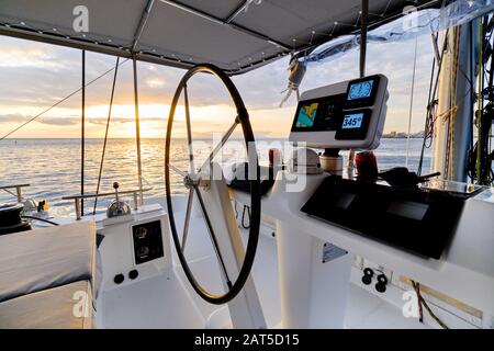 Idilliaco scenario luminoso sole giù Oceano calma vista acqua dal catamarano flybridge ponte scoperto, moderno yacht di lusso dotato di navigazione cruscotto Devi Foto Stock