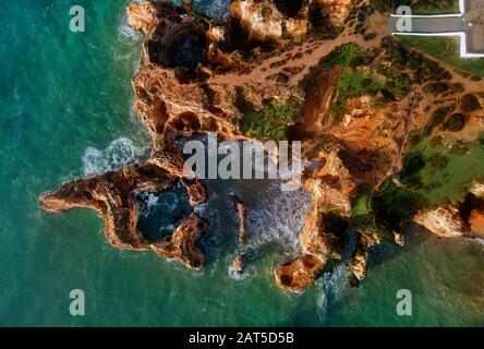 Foto aerea vista Ponta da Piedade punta con gruppo di formazioni rocciose giallo-oro scogliere lungo la costa calcarea, Lagos, Portogallo Foto Stock