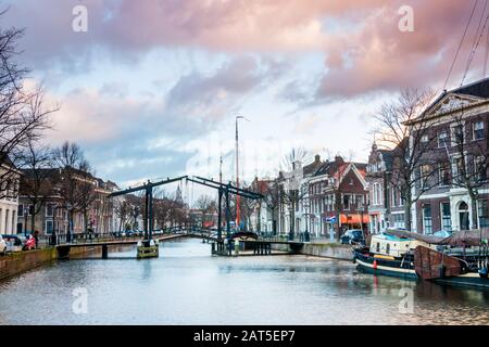 Il centro di Schiedam con belle stradine strette e piccoli canali, foto scattate nelle ore serali con belle nuvole arancioni e blu. Provincia Foto Stock