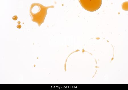 Il caffè versato gocciola sul tavolo bianco. Foto Stock
