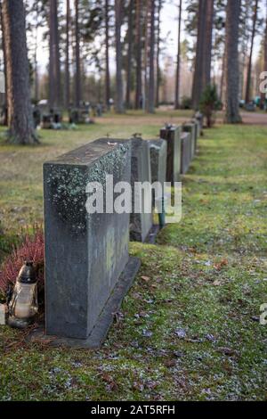 Linea di lapidi anonime in un cimitero