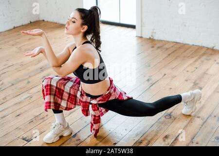 giovane donna flessibile che si allunga mentre gesturing e danza jazz funk Foto Stock