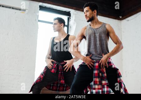 ballerini multiculturali che posano mentre ballano musica jazz in studio di danza Foto Stock