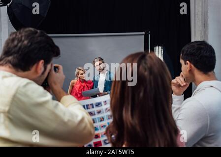fuoco selettivo di modello attraente vicino al direttore d'arte bearded in studio di foto Foto Stock