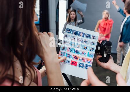 vista ritagliata del direttore artistico e del fotografo che guarda il collage fotografico Foto Stock