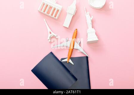 vista dall'alto dei passaporti vicino all'aereo dei giocattoli e delle figurine dai paesi su rosa Foto Stock