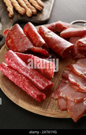 delizioso piatto di carne su tavola di legno su superficie nera Foto Stock