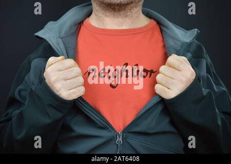 un uomo che mostra la sua t-shirt con la parola vicina su di essa Foto Stock