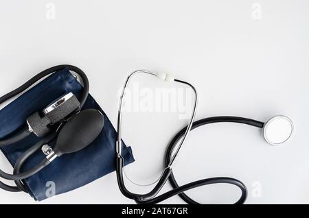 Misuratore della pressione sanguigna con stetoscopio su sfondo bianco. Spazio di copia, disposizione piatta Foto Stock