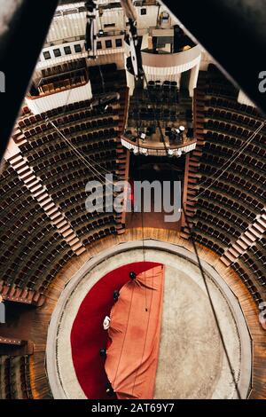 Vista dall'alto degli uomini che posano una copertura rossa sull'arena del circo Foto Stock