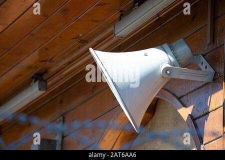 Megafono bianco appeso a un muro di legno Foto Stock