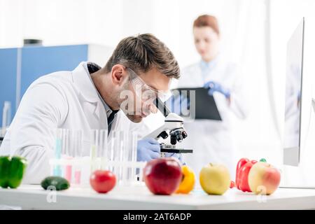 fuoco selettivo di nutrizionista molecolare usando microscopio in laboratorio Foto Stock