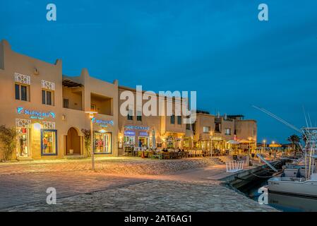 Fronti di shopping illuminati giacenti sul proceso lungo il porto turistico di Abu Tig a el Gouna, Egitto, 14 gennaio 2020