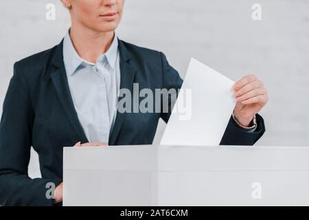 vista ritagliata di businesswoman voting vicino muro di mattoni Foto Stock