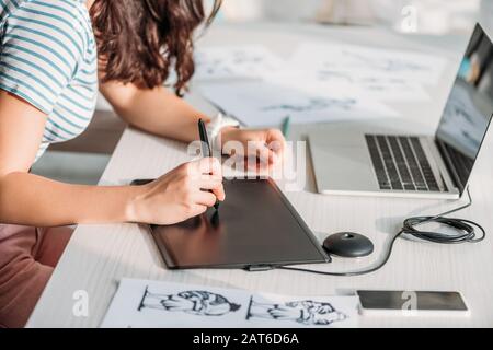 vista ritagliata dell'animatore utilizzando un tablet digitale vicino agli schizzi Foto Stock