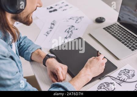 vista ritagliata dell'animatore in cuffie con tablet digitale Foto Stock