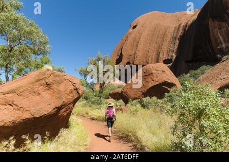 Bushwalker segue il percorso intorno a Uluru (Ayres Rock) nel centro dell'Australia. Foto Stock