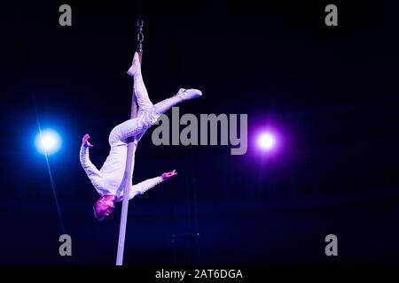 acrobat bilanciamento su palo metallico in arena di circo Foto Stock