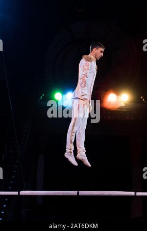 bel gymnasast bilanciamento vicino alla pole in arena di circo Foto Stock