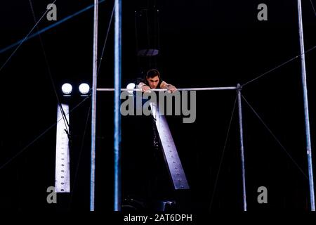 atletica acrobata in esecuzione su bar orizzontali in arena di circo Foto Stock