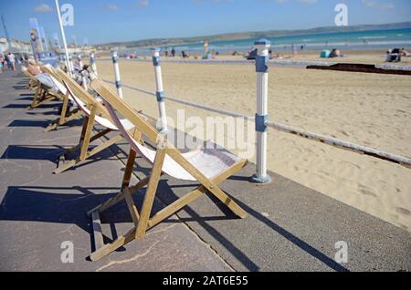 Sedie a sdraio sul lungomare a Weymouth Dorset, Regno Unito Foto Stock