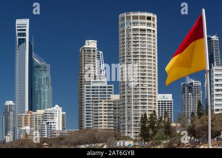 Surfers Paradise, Gold Coast, Queensland, Australia - 13 Ott 2013: Bandiera rossa e gialla con gli edifici di Surfers Paradise sullo sfondo, Foto Stock