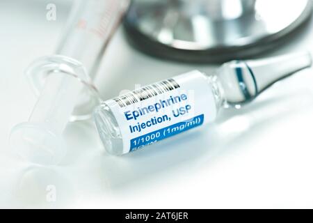 Primo piano della soluzione di iniezione di epinefrina in clear1 ml di ampolle con siringa e stetoscopio. Foto Stock
