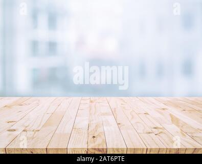 Messa a fuoco selettiva del piano del tavolo in legno su sfondo bianco a parete (grande finestra).Per la visualizzazione del prodotto di montaggio o il layout visivo chiave del progetto Foto Stock