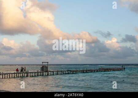 Un molo di legno ramgrillo si estende sull'acqua del Mar dei Caraibi a Mahahual, o Majajual, Quintana Roo, Messico. Foto Stock