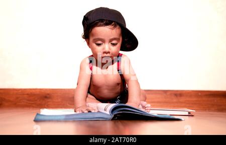 Bambino di sei mesi ragazzo con libro di lettura con espressione . Foto bambino Shoot basso angelo Shot Foto Stock