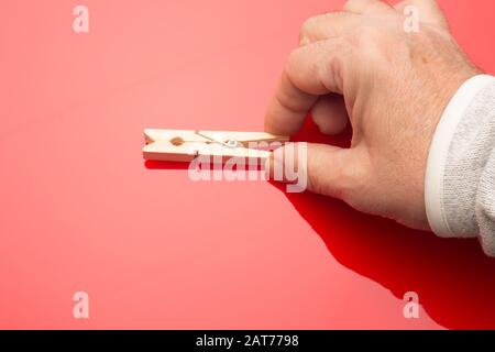 Semplice stendibiancheria in legno per appendere i vestiti o tenere piccole cose; morsetto con un piccolo pezzo metallico che funge da molla per aprire e chiudere il morsetto e. Foto Stock