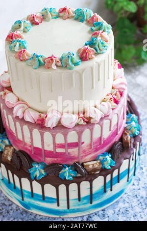 Torta colorata a tre livelli con macchie colorate di cioccolato su sfondo chiaro. Foto per un menu o un catalogo dolciario, la torta nuziale Foto Stock